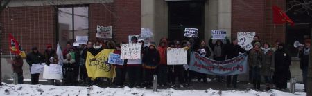 Demonstrators posing outside the office of Liberal MPP Rick Bartolucci and demanding a raise to social assistance rates and an end to the austerity agenda. (Photo by Scott Neigh)