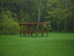 The sun shelter sits in a small meadow.